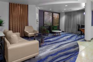 Fairfield Inn & Suites by Marriott Matthews Charlotte في تشارلوت: غرفة انتظار مع أريكة وطاولة