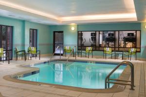 uma piscina num quarto de hotel com cadeiras e mesas em SpringHill Suites Chicago Lincolnshire em Lincolnshire