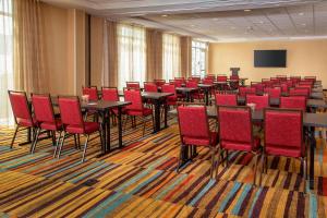 Fairfield Inn & Suites by Marriott Harrisburg International Airport في Middletown: قاعة اجتماعات مع طاولات وكراسي حمراء