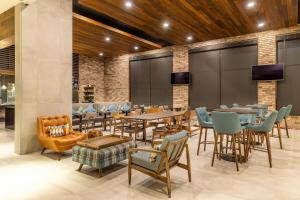 a restaurant with tables and chairs and televisions at Four Points by Sheraton Monterrey Airport in Monterrey