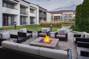 a patio with furniture and a fire pit in a courtyard at Courtyard by Marriott Detroit Warren in Warren