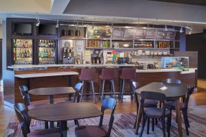 un restaurante con mesas y sillas y un bar en Courtyard by Marriott Detroit Warren, en Warren