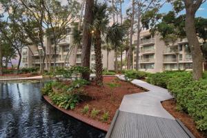 a walkway in front of a building with a river at Marriott's Monarch at Sea Pines in Hilton Head Island