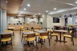 a restaurant with tables and chairs and a bar at Fairfield by Marriott Inn & Suites Asheville Outlets in Asheville