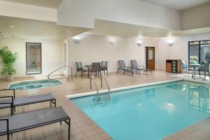 una piscina en una habitación de hotel con mesas y sillas en Fairfield by Marriott Inn & Suites Asheville Outlets, en Asheville