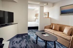 a living room with a couch and a table at Fairfield by Marriott Inn & Suites Asheville Outlets in Asheville