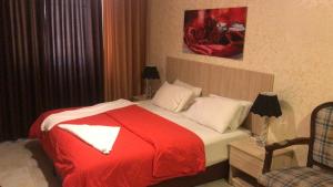 una camera d'albergo con un letto con una coperta rossa di Suzan Hotel Apartments ad Amman