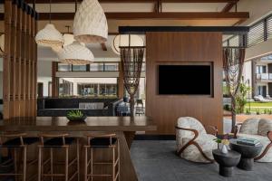 a living room with a dining table and a tv at AC Hotel by Marriott Maui Wailea in Wailea