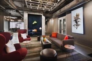 a lobby with a couch and chairs and a table at Aloft Atlanta Perimeter Center in Sandy Springs