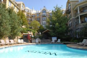 une grande piscine en face d'un grand bâtiment dans l'établissement Le Westin Tremblant, à Mont-Tremblant