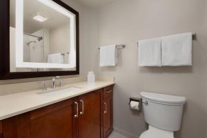 a bathroom with a toilet and a sink and a mirror at Marriott's BeachPlace Towers in Fort Lauderdale