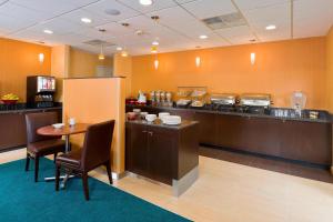 a restaurant with a counter and a table with chairs at Residence Inn Canton in North Canton