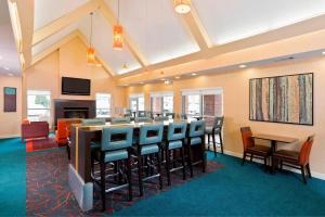 a large room with a bar and chairs at Residence Inn Canton in North Canton