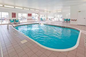 a large swimming pool in a building with blue chairs at Residence Inn Canton in North Canton