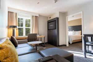 a hotel room with a couch and a bed at Residence Inn by Marriott Princeton at Carnegie Center in Princeton