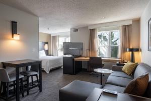 a hotel room with a bed and a living room at Residence Inn by Marriott Princeton at Carnegie Center in Princeton