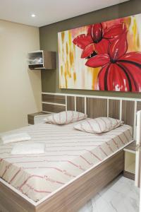 uma cama num quarto com uma pintura na parede em Hotel Tenda Obsession em São Paulo