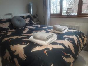 a bed with a blanket with white birds on it at ALVASTON, DERBY Entire 1 Bed House & South Facing Patio Garden in Derby