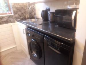 una cucina con lavatrice e lavandino di ALVASTON, DERBY Entire 1 Bed House & South Facing Patio Garden a Derby