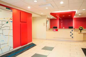 an office lobby with red walls and a map on the wall at TownePlace Suites Des Moines Urbandale in Johnston