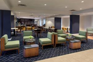 a waiting room with green chairs and tables at Courtyard by Marriott Basking Ridge in Basking Ridge