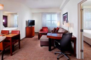 a hotel room with a desk and a bedroom at Residence Inn by Marriott Tallahassee Universities at the Capitol in Tallahassee