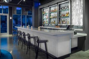 a bar in a restaurant with stools at Aloft Gainesville University Area in Gainesville