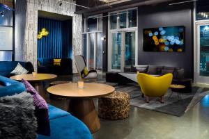 a lobby with couches and tables and chairs at Aloft Gainesville University Area in Gainesville