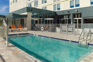 a swimming pool in front of a building at Aloft Gainesville University Area in Gainesville
