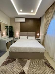 sypialnia z łóżkiem, 2 stołami i oknem w obiekcie MJ Private APARTMENT w Rijadzie