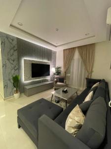 salon z kanapą i telewizorem w obiekcie MJ Private APARTMENT w Rijadzie