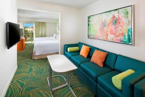 a hotel room with a blue couch and a bed at SpringHill Suites by Marriott Orlando Lake Buena Vista in Marriott Village in Orlando