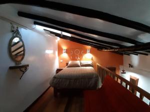1 dormitorio con cama y espejo en la pared en Hatun Quilla, en Cusco