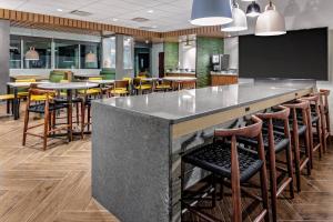 un bar en un restaurante con mesas y sillas en Fairfield Inn & Suites by Marriott Queensbury Glens Falls/Lake George en Queensbury