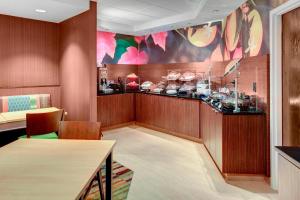 un restaurante con un bar con mesa y sillas en Fairfield Inn & Suites by Marriott Atlanta Alpharetta en Alpharetta