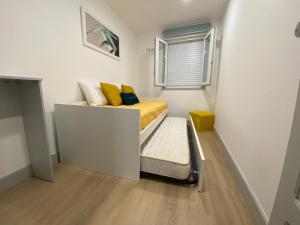 um pequeno quarto com uma cama e uma janela em Casa Rocha em Pinhão