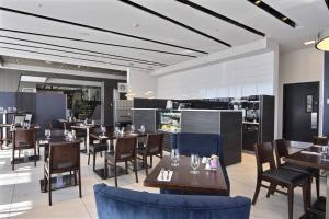 a restaurant with tables and chairs and a kitchen at Courtyard by Marriott Quebec City in Quebec City