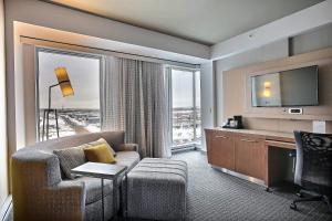 a hotel room with a couch and a desk and a television at Courtyard by Marriott Quebec City in Quebec City