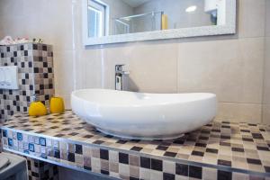 a bathroom with a large white sink on a tiled counter at Apartman Sunny Vacay in Kaštela