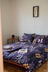 Varilhes的住宿－bienvenue chez vous 09，一间卧室配有一张带紫色棉被的床