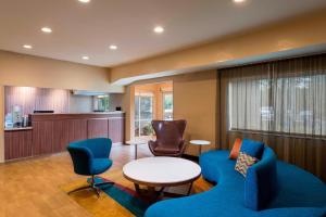 uma sala de espera com cadeiras azuis e uma mesa em Fairfield Inn and Suites St Petersburg Clearwater em Clearwater