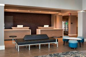 a waiting area with a bench and tables and chairs at Residence Inn by Marriott Lancaster in Lancaster