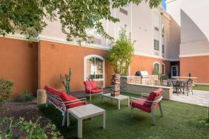 een patio met rode stoelen en een tafel bij TownePlace Suites by Marriott Tucson Williams Centre in Tucson