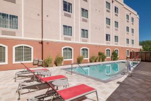 a hotel patio with a pool and chairs and a building at TownePlace Suites by Marriott Tucson Williams Centre in Tucson