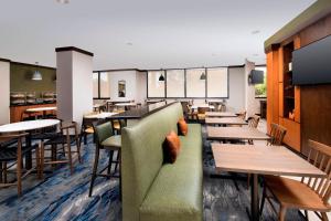 邁阿密的住宿－萬豪費爾菲爾德客棧及套房邁阿密機場南部酒店，餐厅设有桌椅和绿色沙发