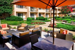 a patio with tables and chairs and an umbrella at Courtyard by Marriott New Carrollton Landover in Landover