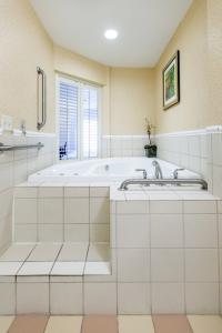 a white bathroom with a tub and a window at Fairfield Inn & Suites Toledo North in Toledo
