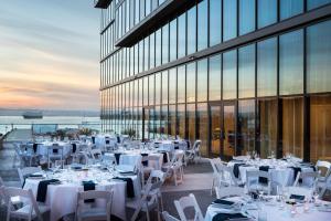 um restaurante com mesas e cadeiras brancas e um edifício em Residence Inn by Marriott San Diego Downtown/Bayfront em San Diego