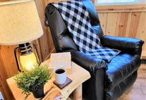 a leather chair sitting next to a table with a book at Sequoia Trails, mountains, fun & relax in Ponderosa