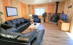 a living room with a leather couch and a fireplace at Sequoia Trails, mountains, fun & relax in Ponderosa